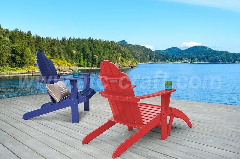 Colorful Adirondack chairs, one red and one blue, set on a wooden deck overlooking a scenic lake and forested mountains, creating a peaceful outdoor retreat